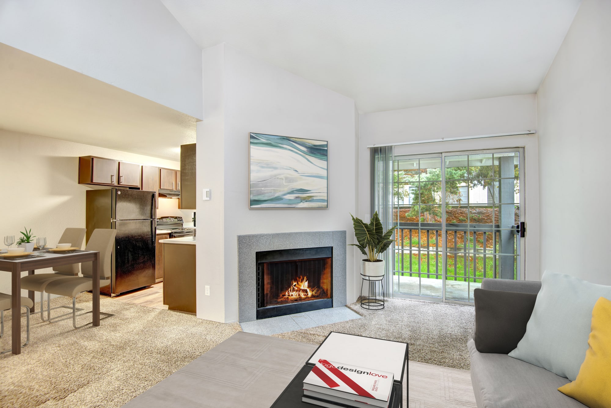 A spacious living room and dining room complete with a fireplace at Wellington Apartment Homes in Silverdale, Washington