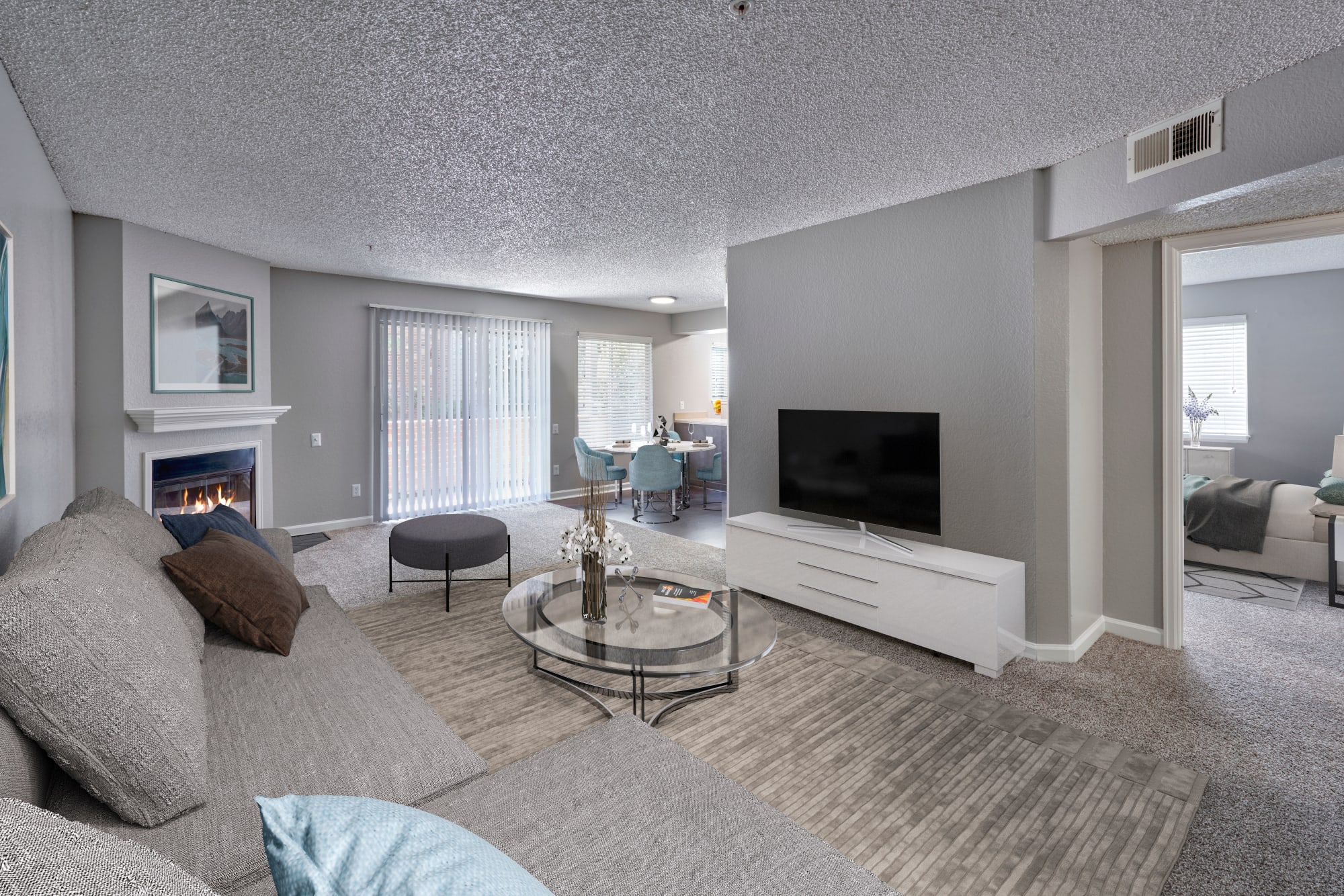 A spacious living room filled with sunlight and a fireplace at Arapahoe Club Apartments in Denver, Colorado