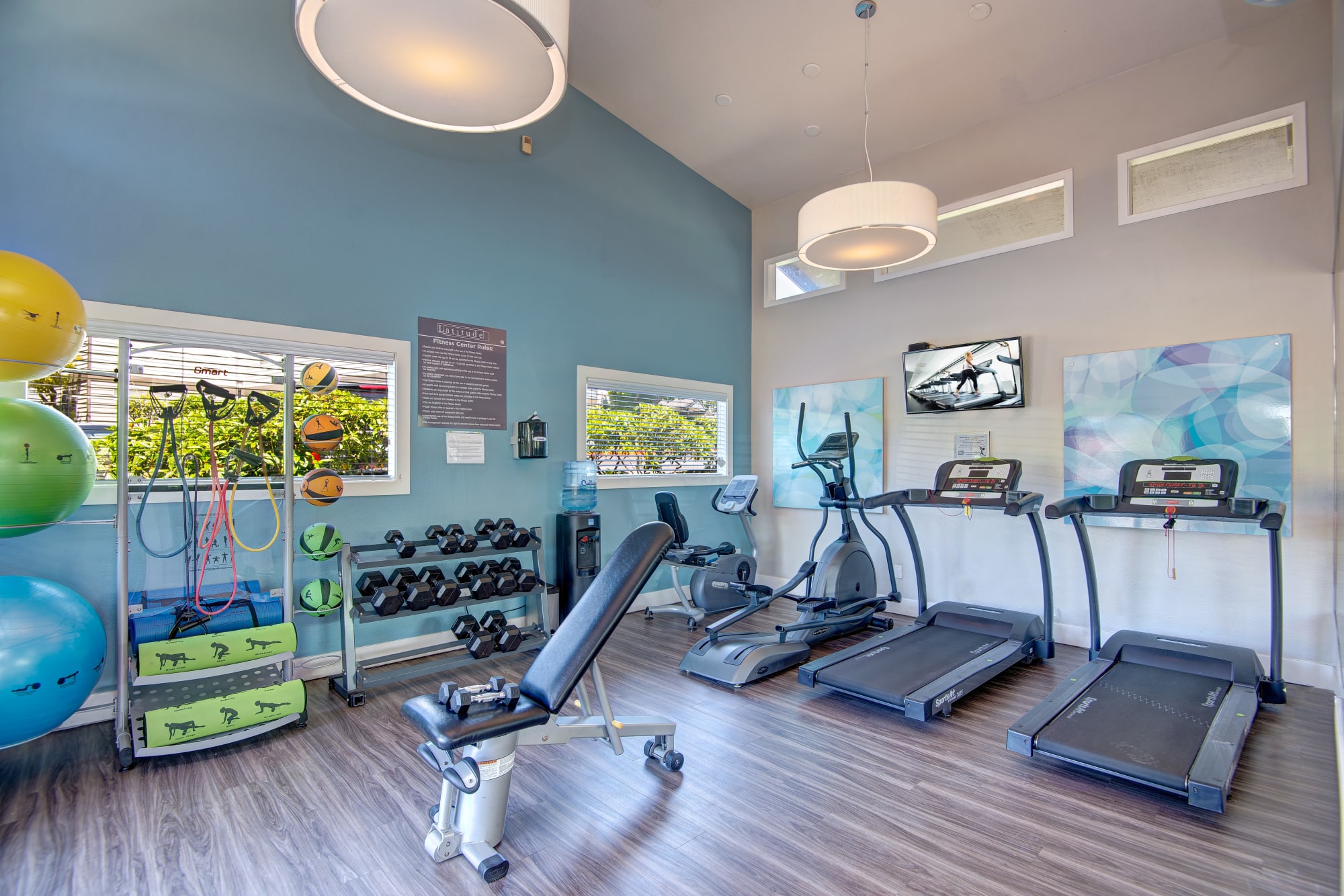 Fitness center with cardio machines and free weights at Latitude Apartments in Everett, Washington
