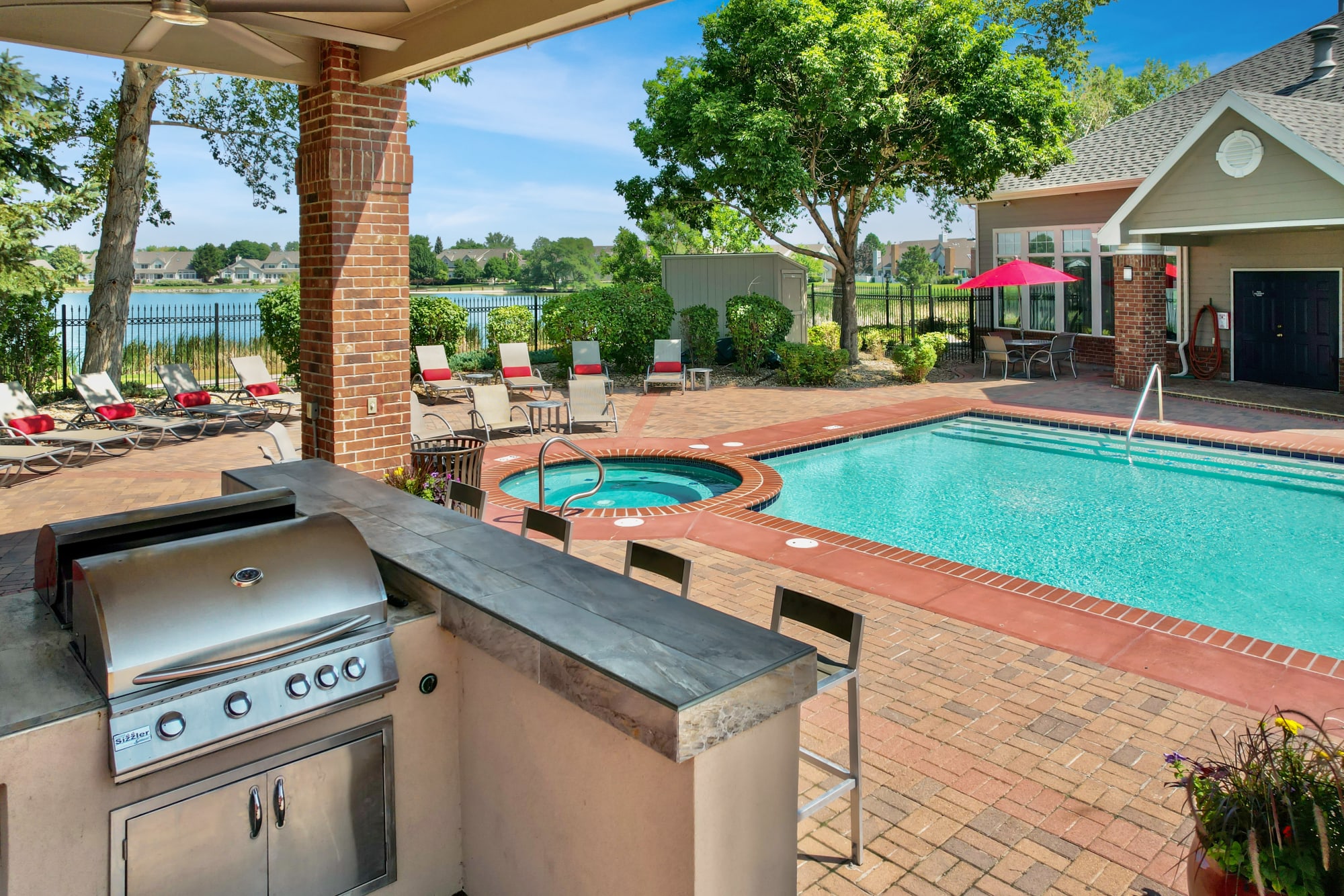 Poolside covered BBQ area with bar top seating at Promenade at Hunter's Glen Apartments in Thornton, Colorado