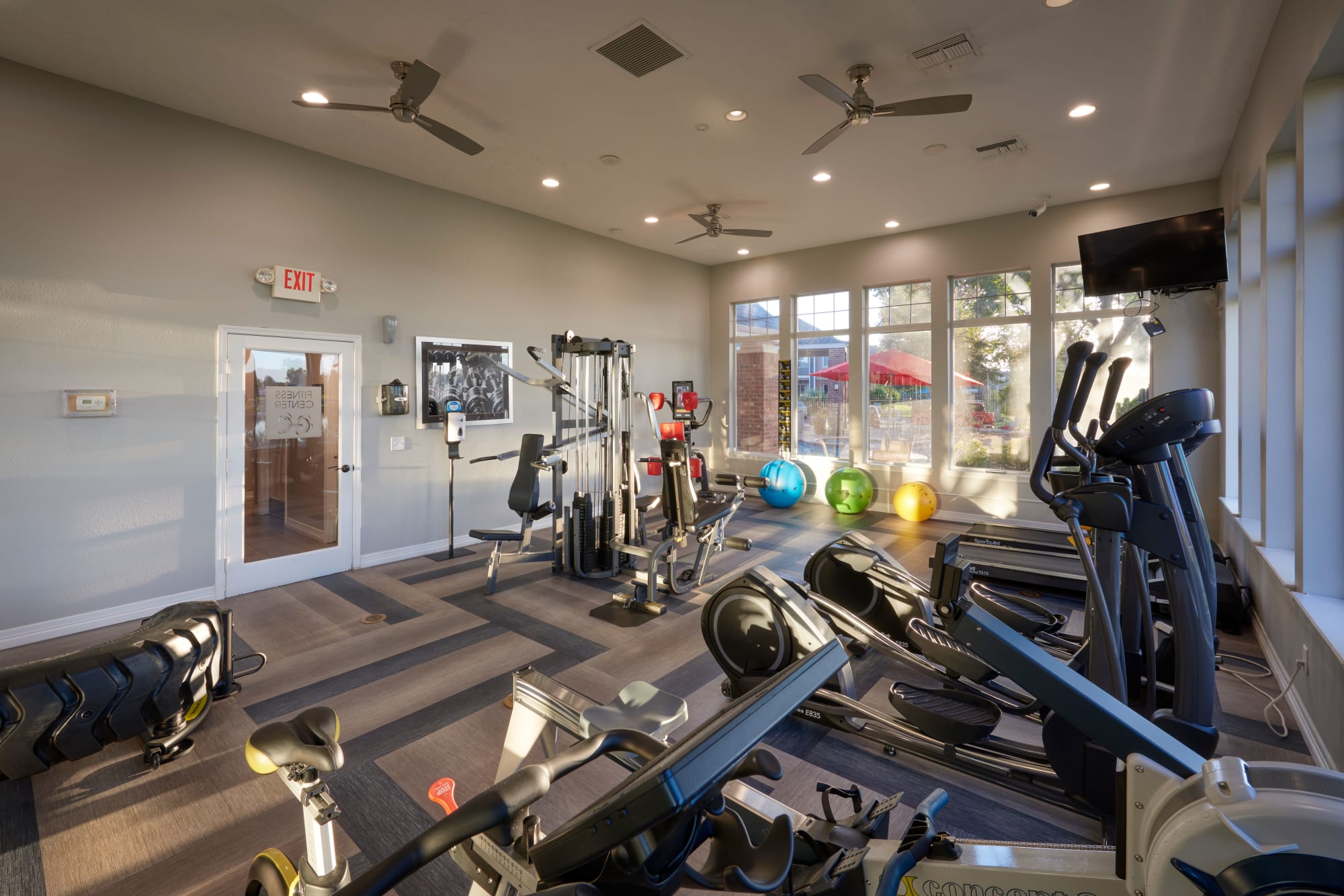 Fully equipped fitness center with lake views at Promenade at Hunter's Glen Apartments in Thornton, Colorado