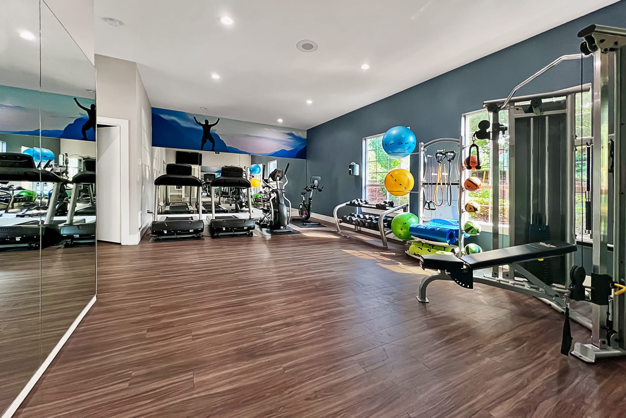 Fitness room with cardio machines and free weights at Newport Crossing Apartments in Newcastle, Washington