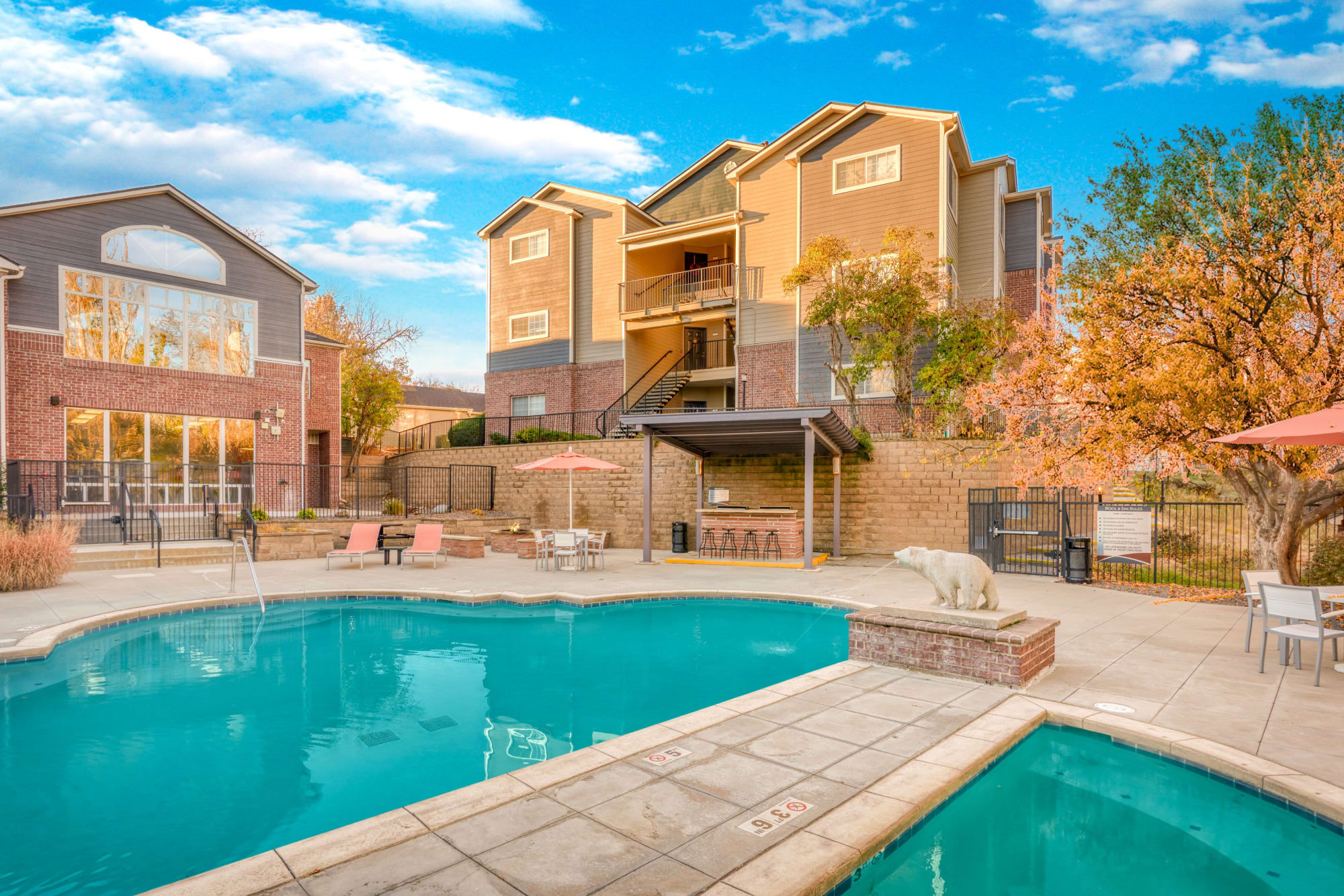 The spa and pool with lounge chairs, umbrellas, BBQ and corn hole at The Crossings at Bear Creek Apartments in Lakewood, Colorado