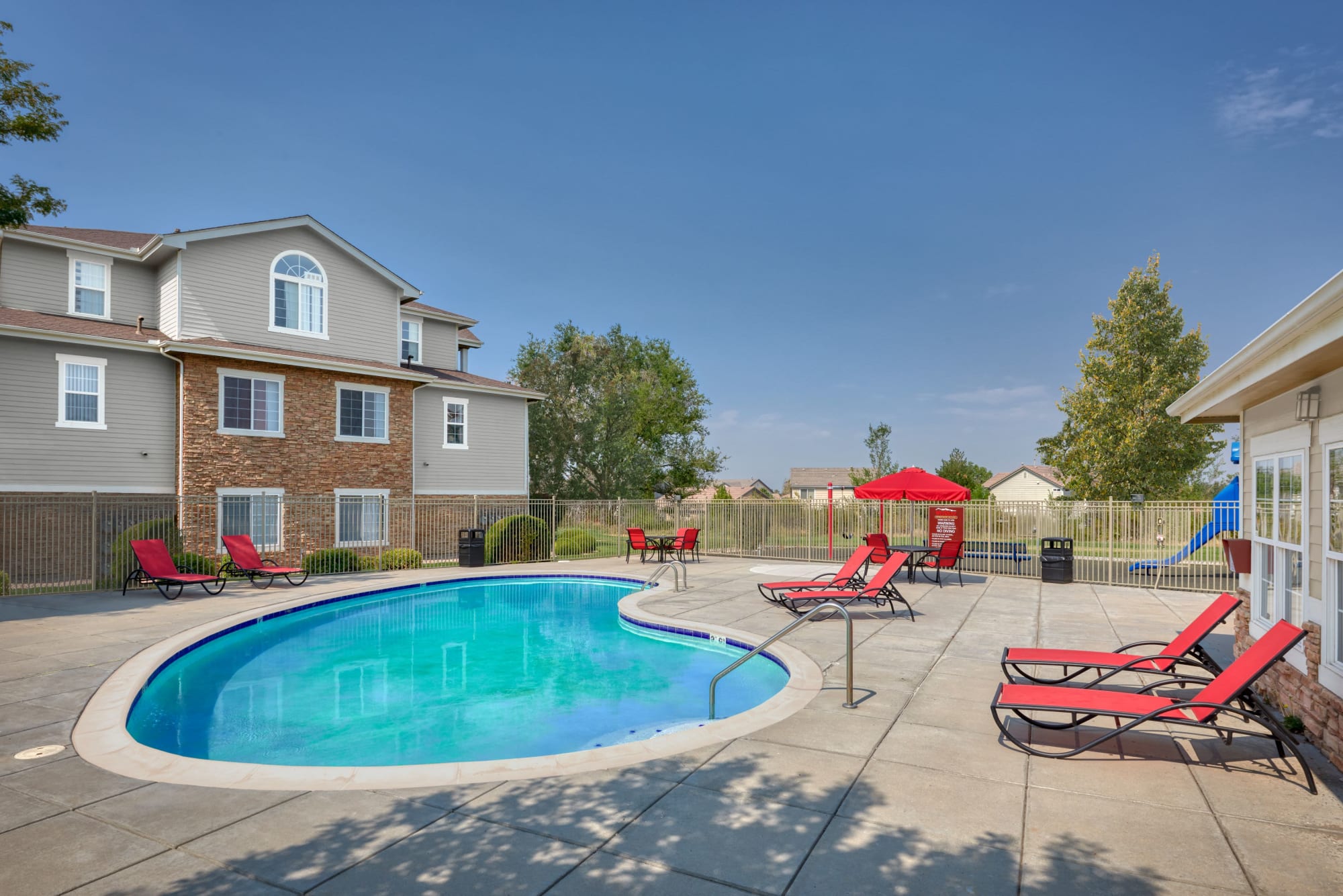 Pool and spa with lounge chairs and umbrellas at Westridge Apartments in Aurora, Colorado