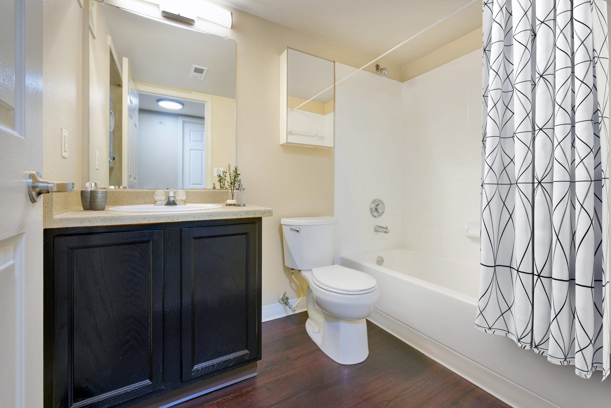 Bathroom with pedestal sink and tub at Crossroads at City Center Apartments in Aurora, Colorado