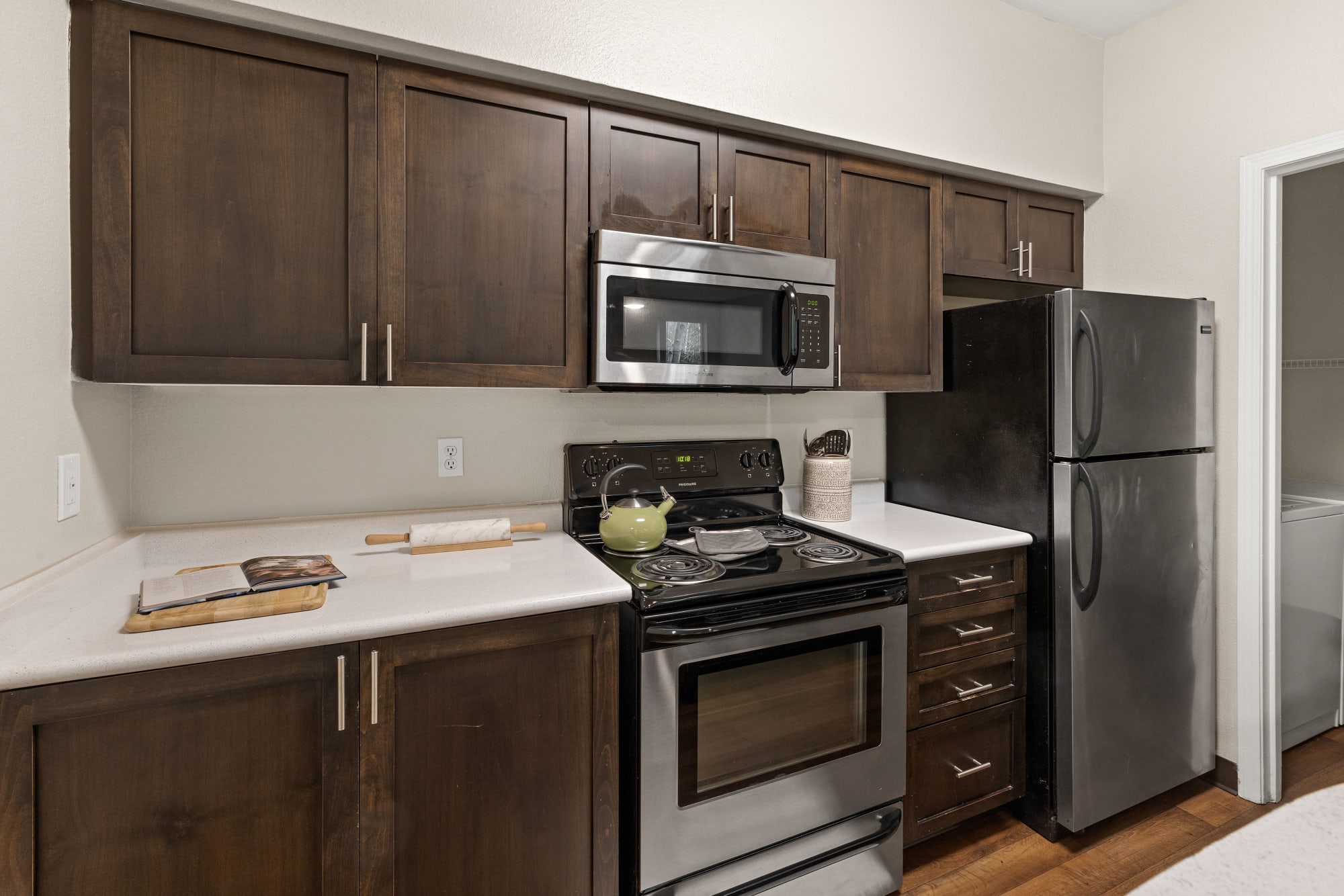 Brown Renovated Kitchen with White Quartz Counters at Wildreed Apartments in Everett, Washington