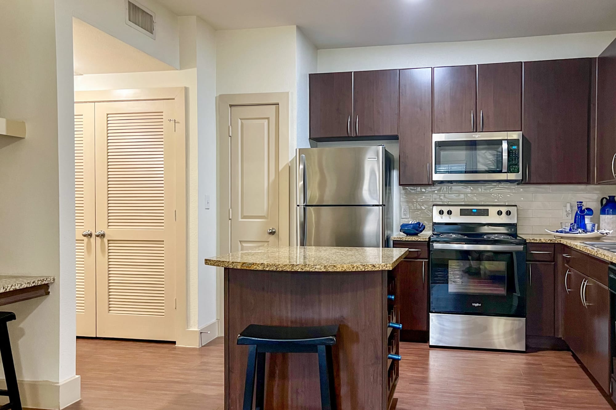 Renovated kitchen with white cabinets and stainless steel appliances at Broadstone Grand Avenue in Pflugerville, Texas