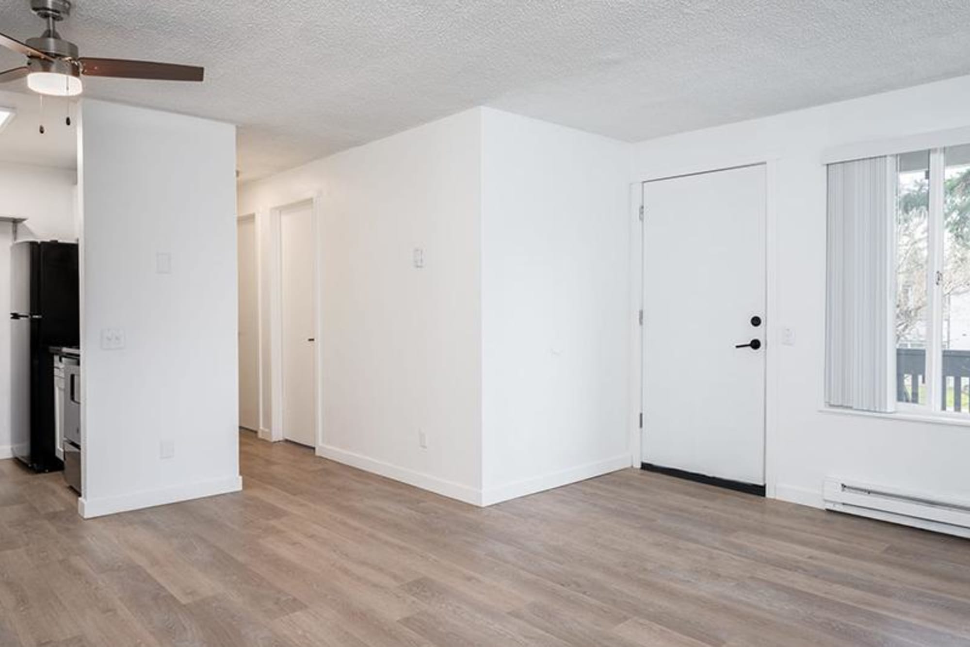 Spacious living room and front door entrance to an apartment at Capri in Mountlake Terrace, Washington