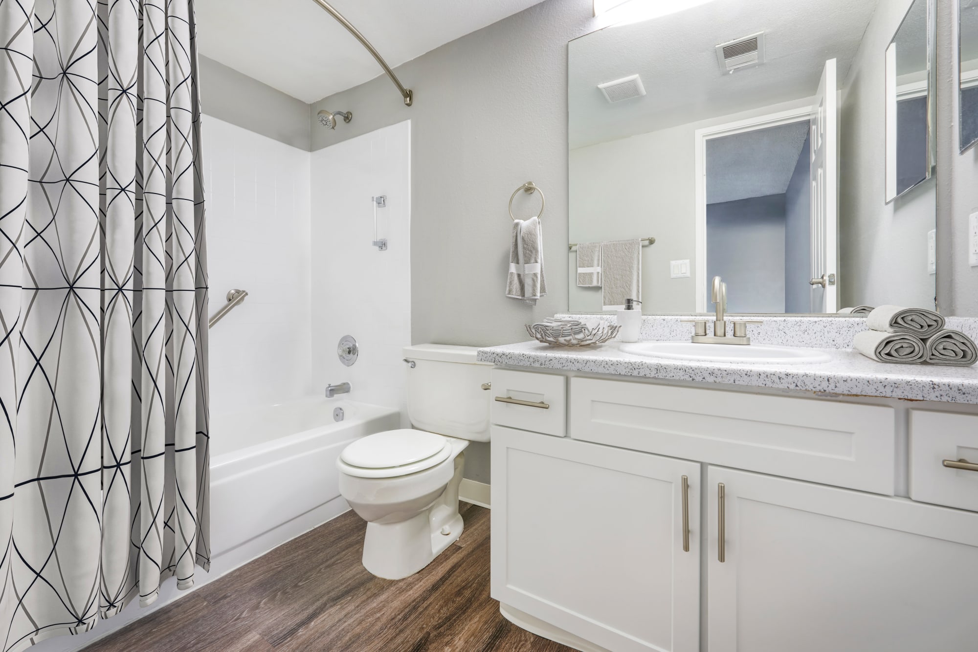 A model bathroom with white cabinets at Alton Green Apartments in Denver, Colorado