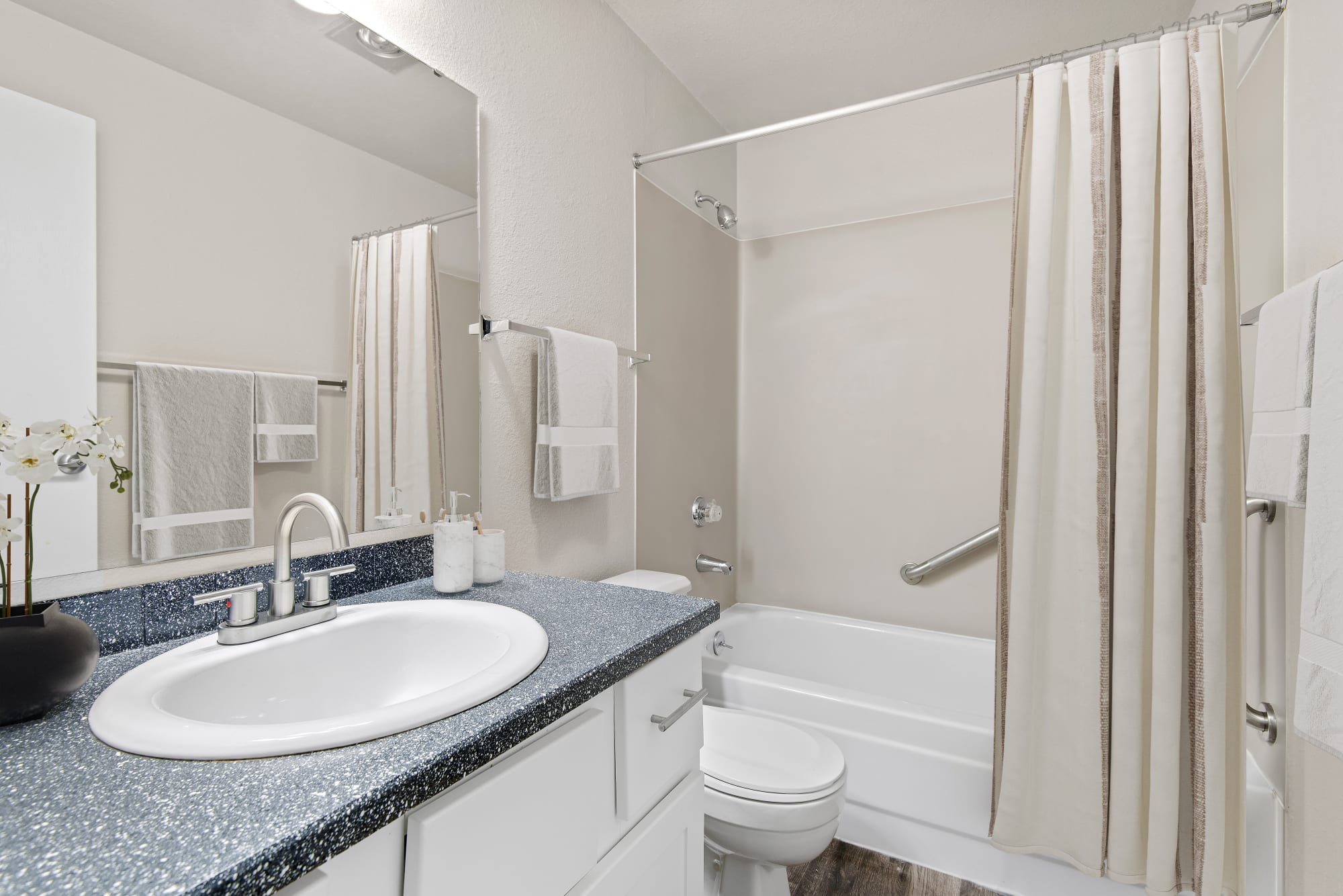 A stylishly modern bathroom with renovated white cabinets at Wellington Apartment Homes in Silverdale, Washington