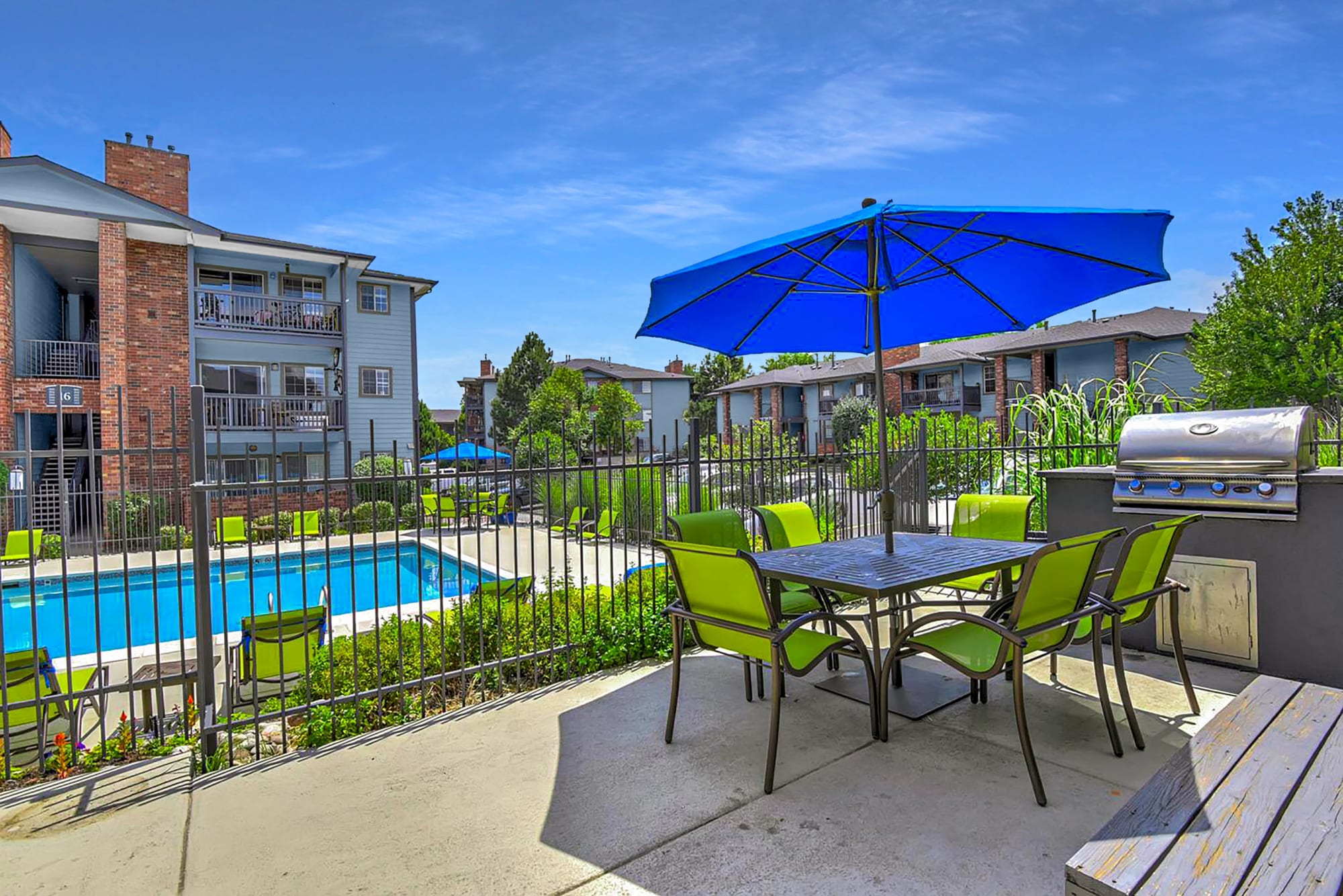 Umbrella covered seating overlooking the pool at Arapahoe Club Apartments in Denver, Colorado