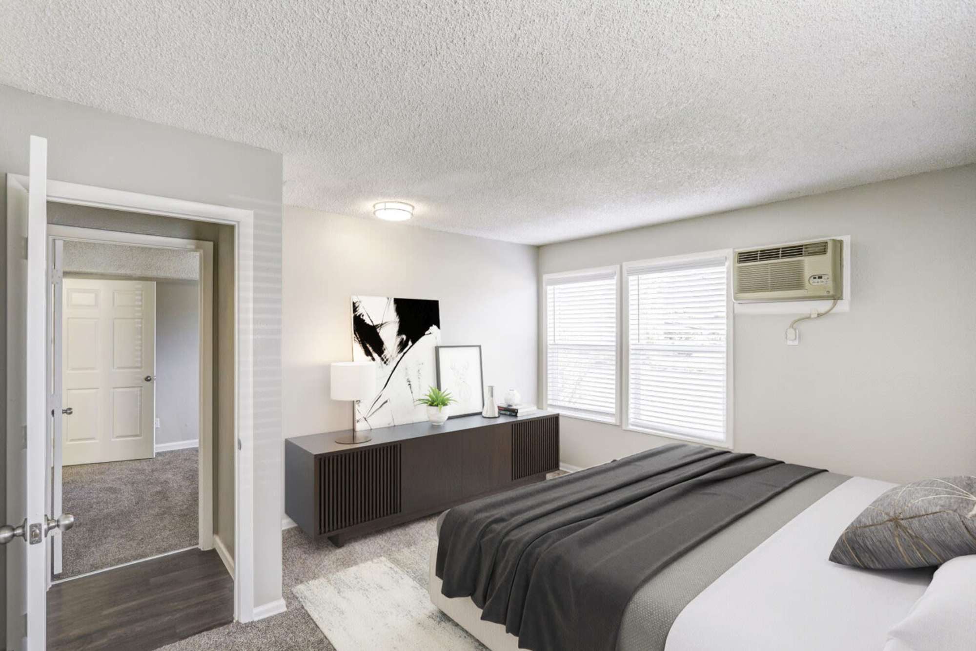 A furnished apartment bedroom with a window at Ascent at Lowry in Denver, Colorado