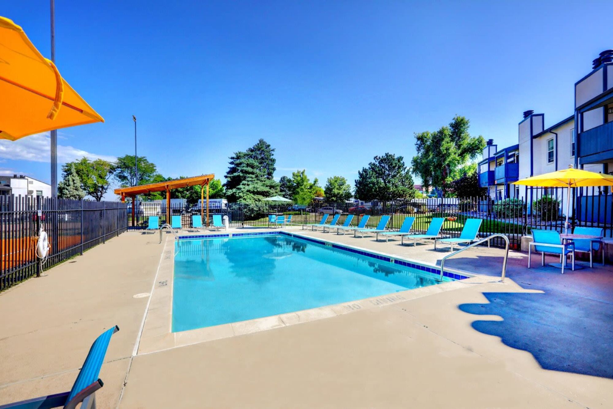 Pool with lounge chairs and umbrellas at Ascent at Lowry in Denver, Colorado