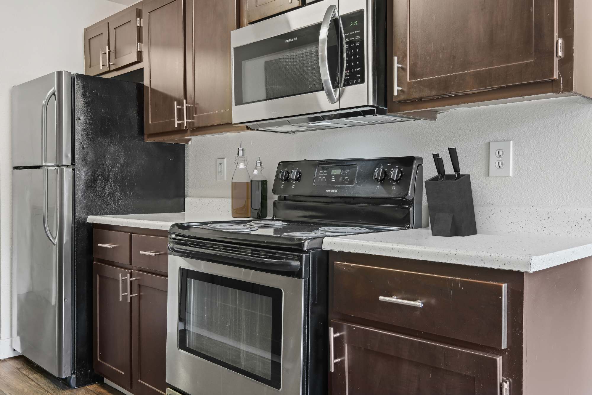 Brown cabinets in a renovated kitchen with stainless steel appliances at Renaissance at 29th Apartments in Vancouver, Washington