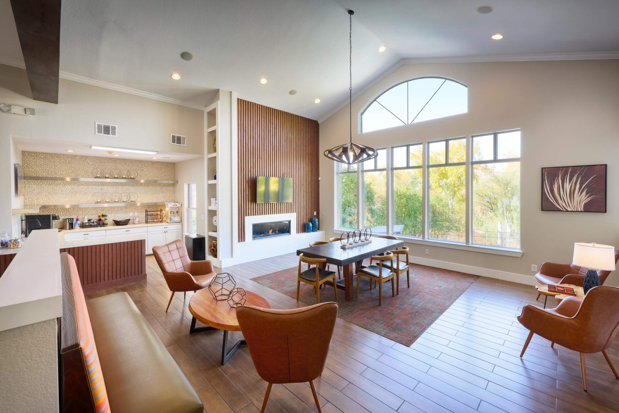 The interior clubhouse lounge with a conference table and a fireplace at The Crossings at Bear Creek Apartments in Lakewood, Colorado