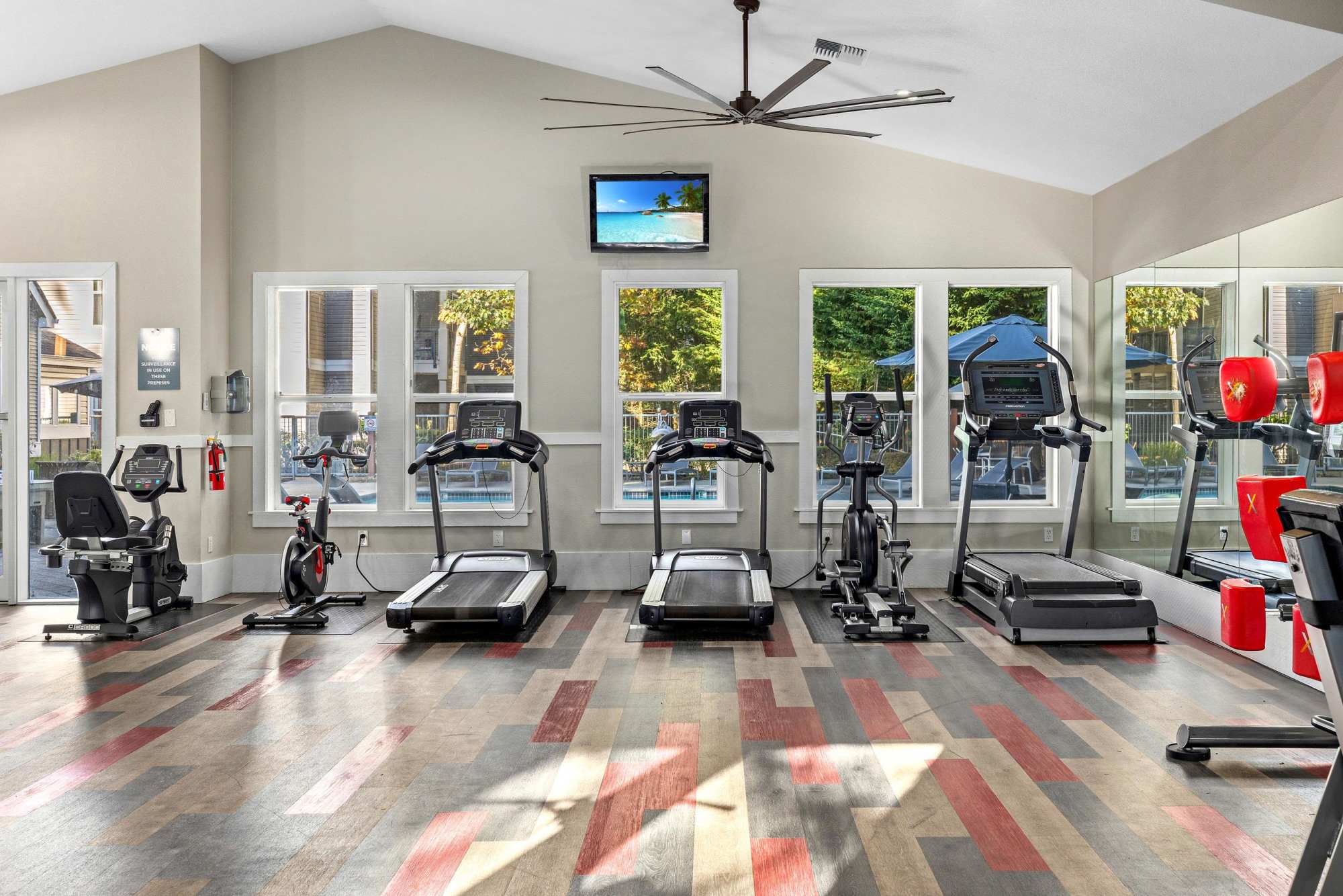Newly renovated fitness center with views to the pool at Wildreed Apartments in Everett, Washington