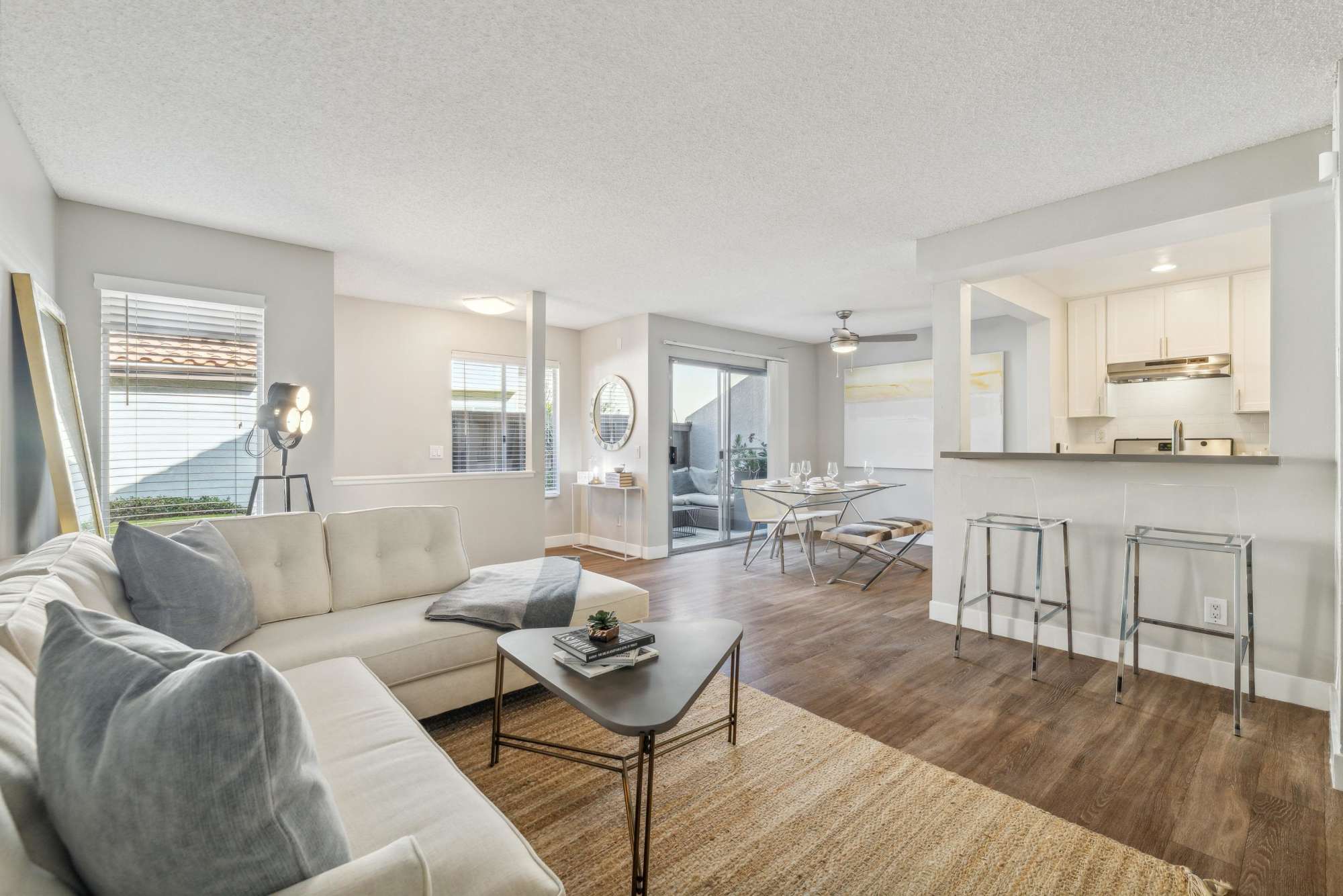 A spacious living room and dining room with wood-style flooring at Portofino Townhomes in Wilmington, California