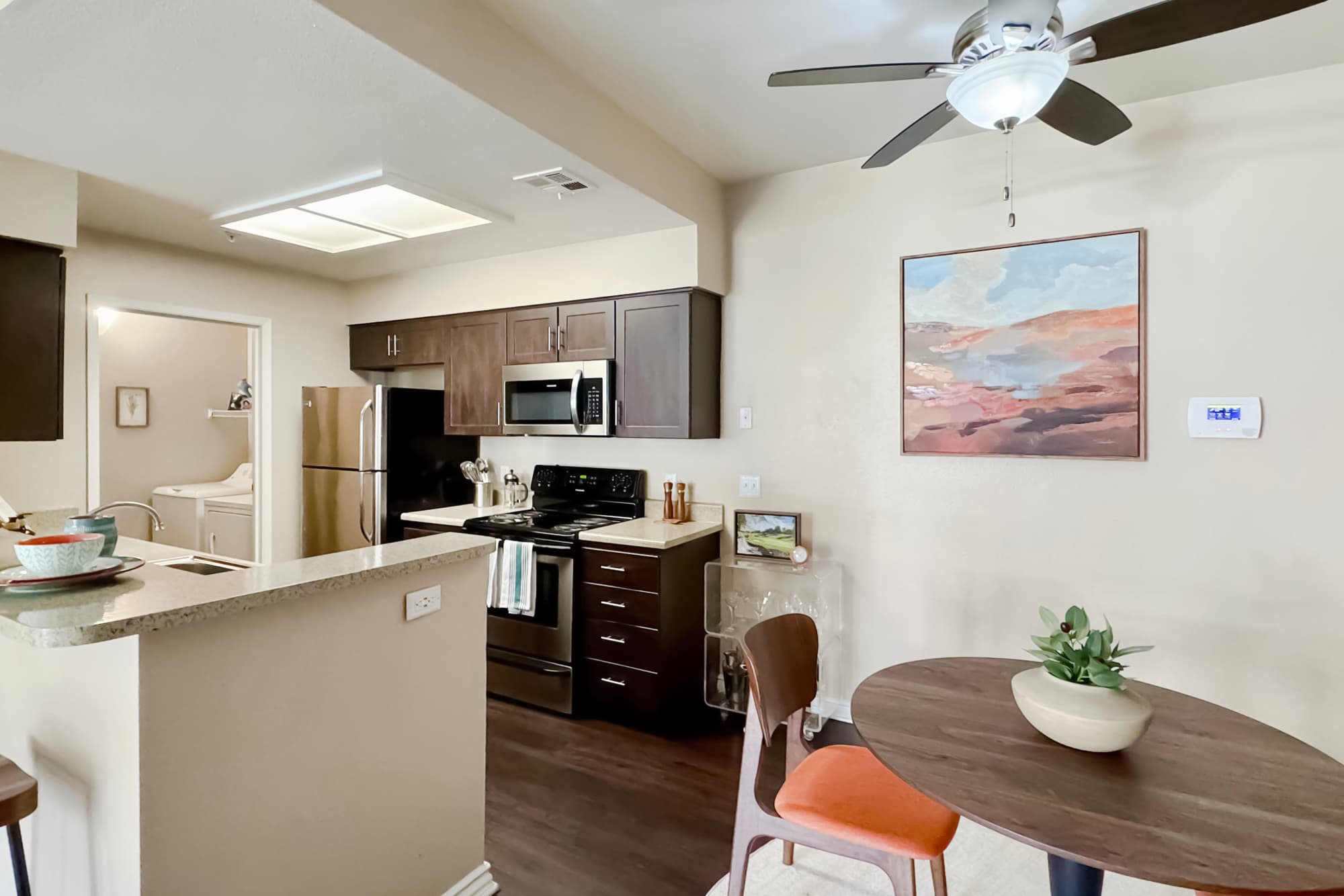 Brown renovated kitchen and dining room view with stainless steel appliances at Sierra Del Oro Apartments in Corona, California