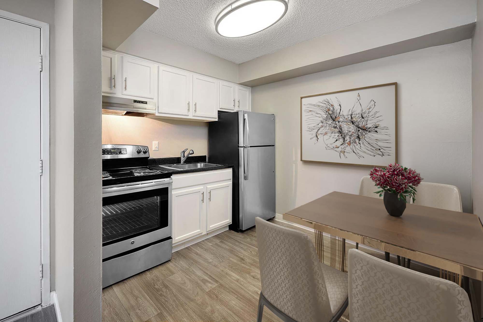 Newly renovated home with white kitchen cabinetry and stainless steel appliances at Ascent at Havana in Denver, Colorado