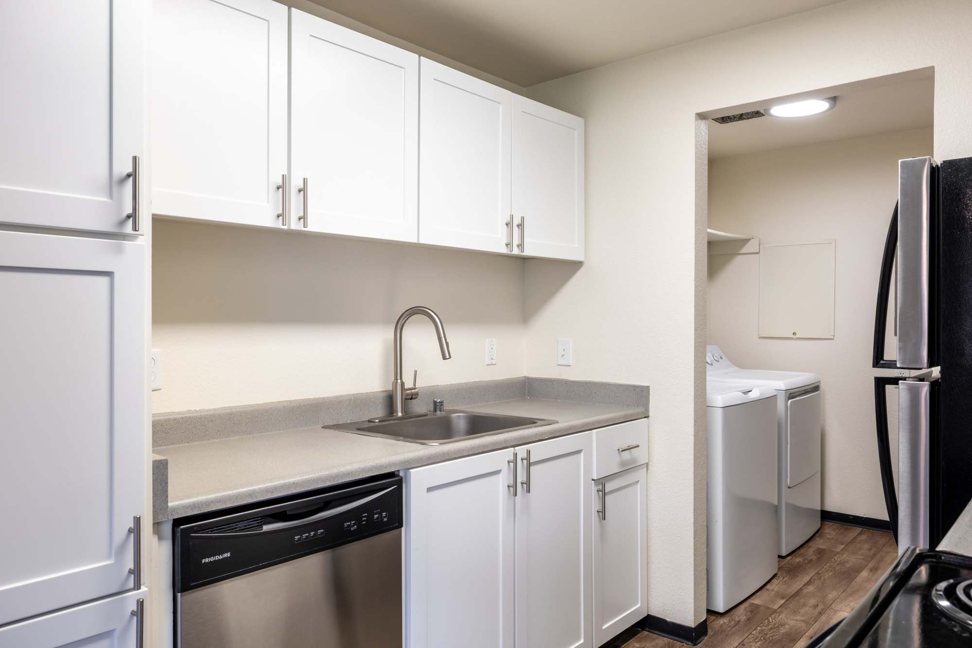 Kitchen with white cabinets and laundry room on the side at at Renaissance at 29th Apartments in Vancouver, Washington