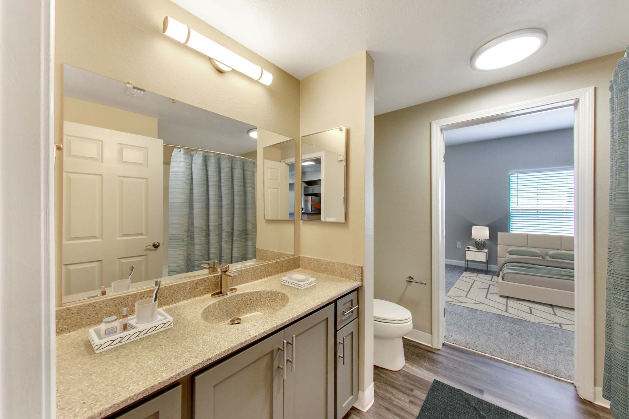 Bathroom with a large mirror at Avion Apartments in Rancho Cordova, California