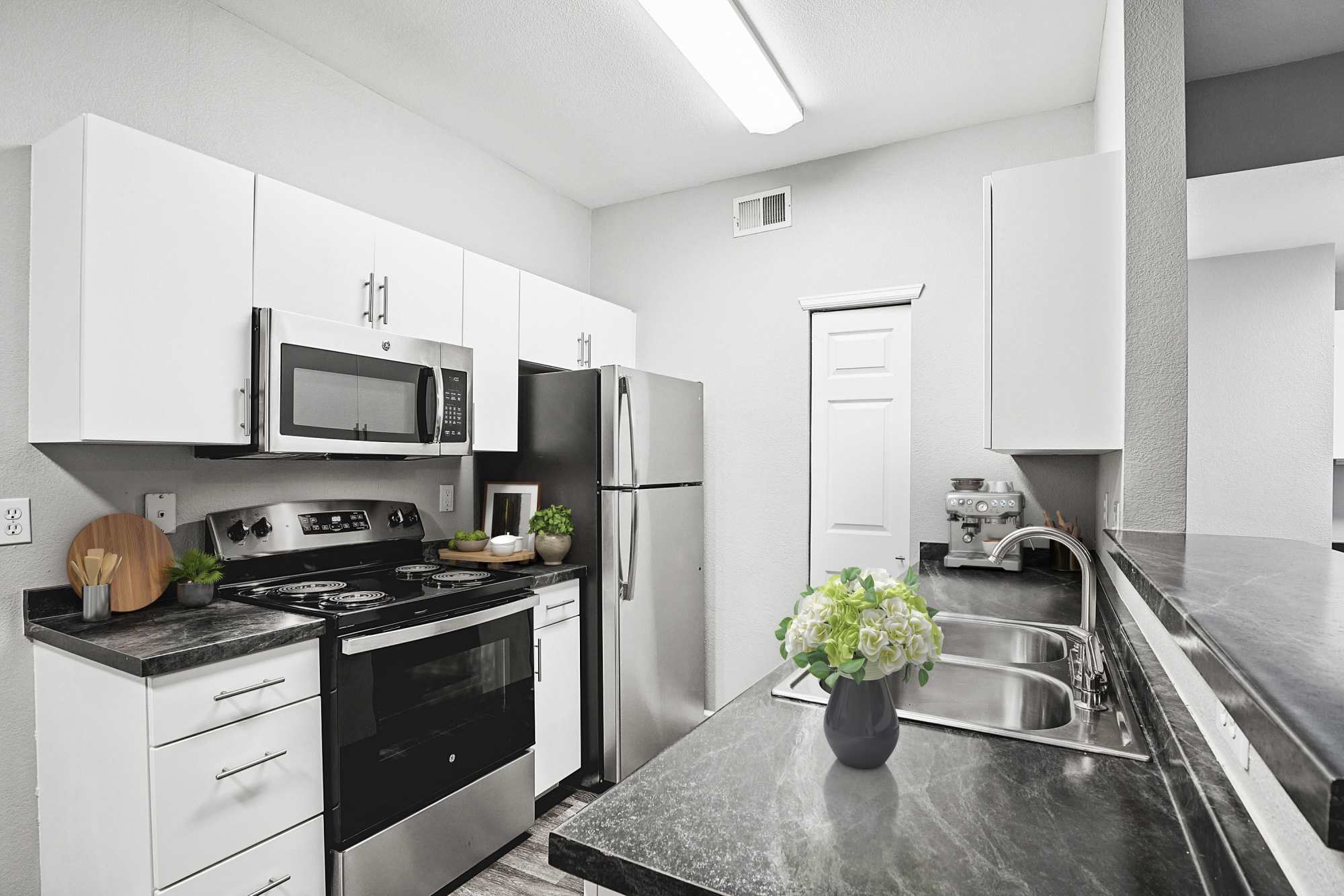 Renovated kitchen with white cabinets at Crestone Apartments in Aurora, Colorado