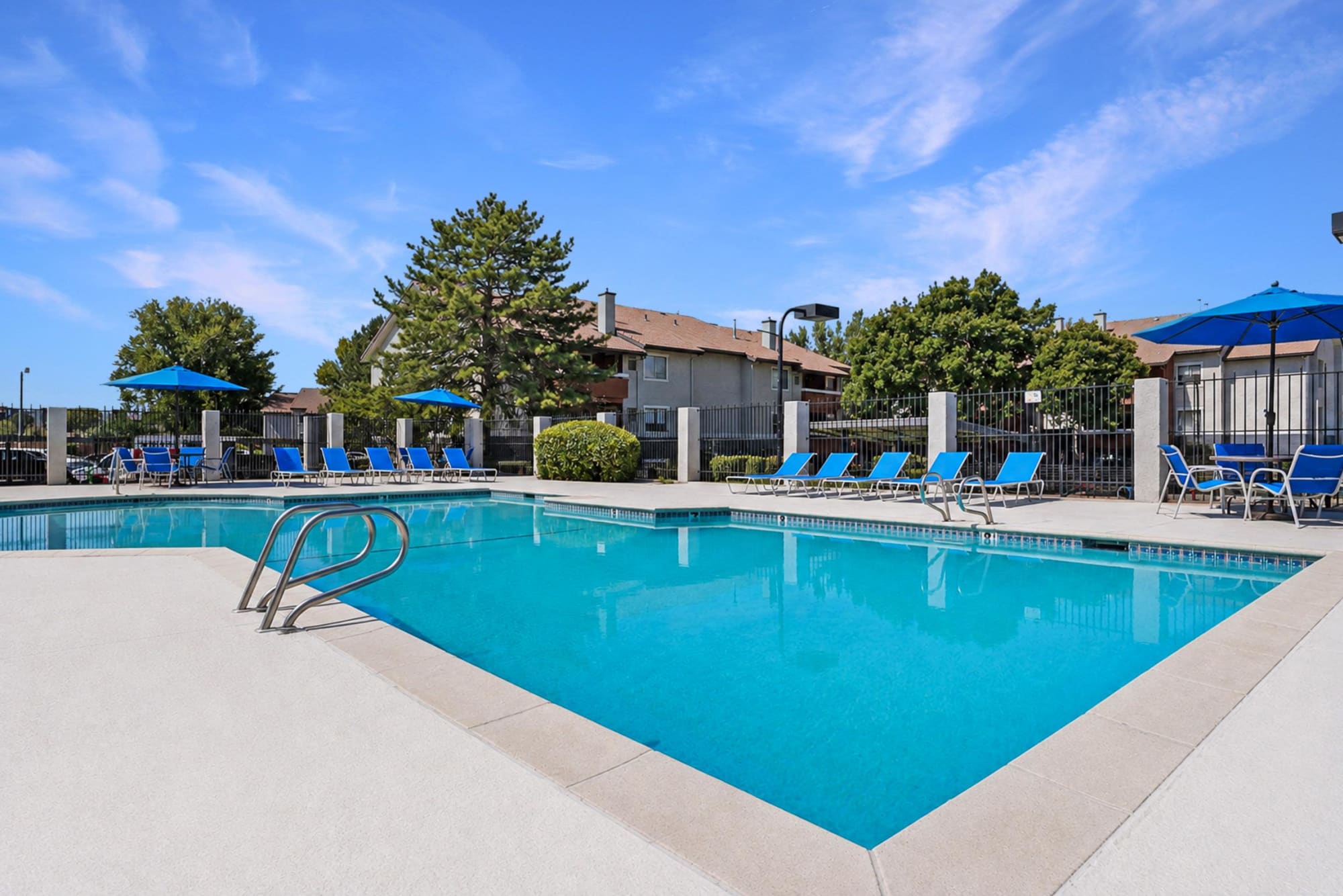 Sparkling community swimming pool with lounge chairs at Shadowbrook Apartments in West Valley City, Utah