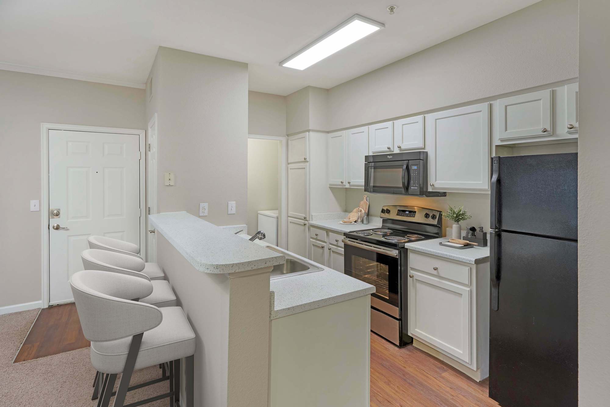 Kitchen with stainless-steel appliances and a breakfast bar at Skyecrest Apartments in Lakewood, Colorado