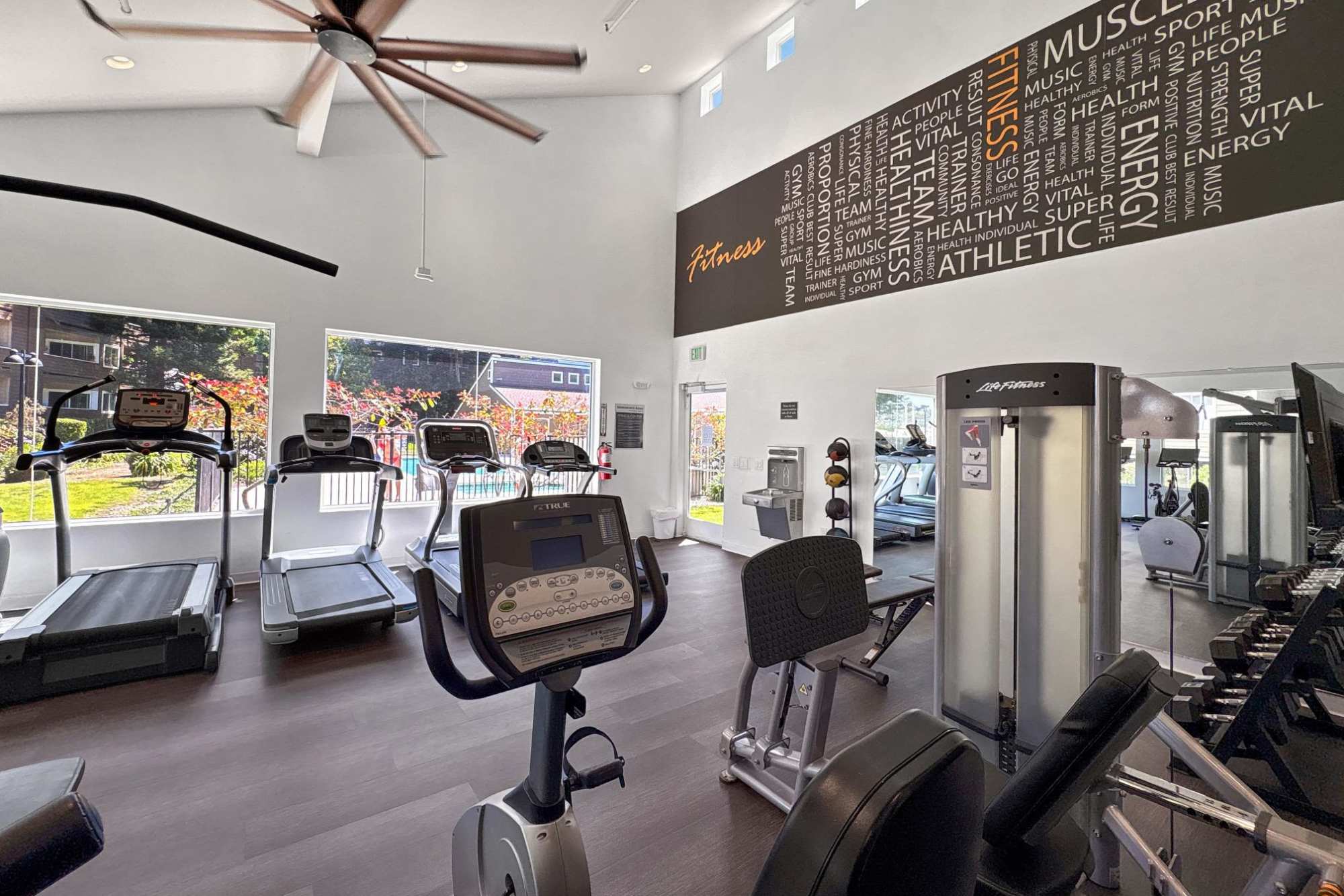 Full-Equipped Fitness Center with Cardio Machines with View Out to the Pool at Serramonte Ridge Apartment Homes in Daly City, California