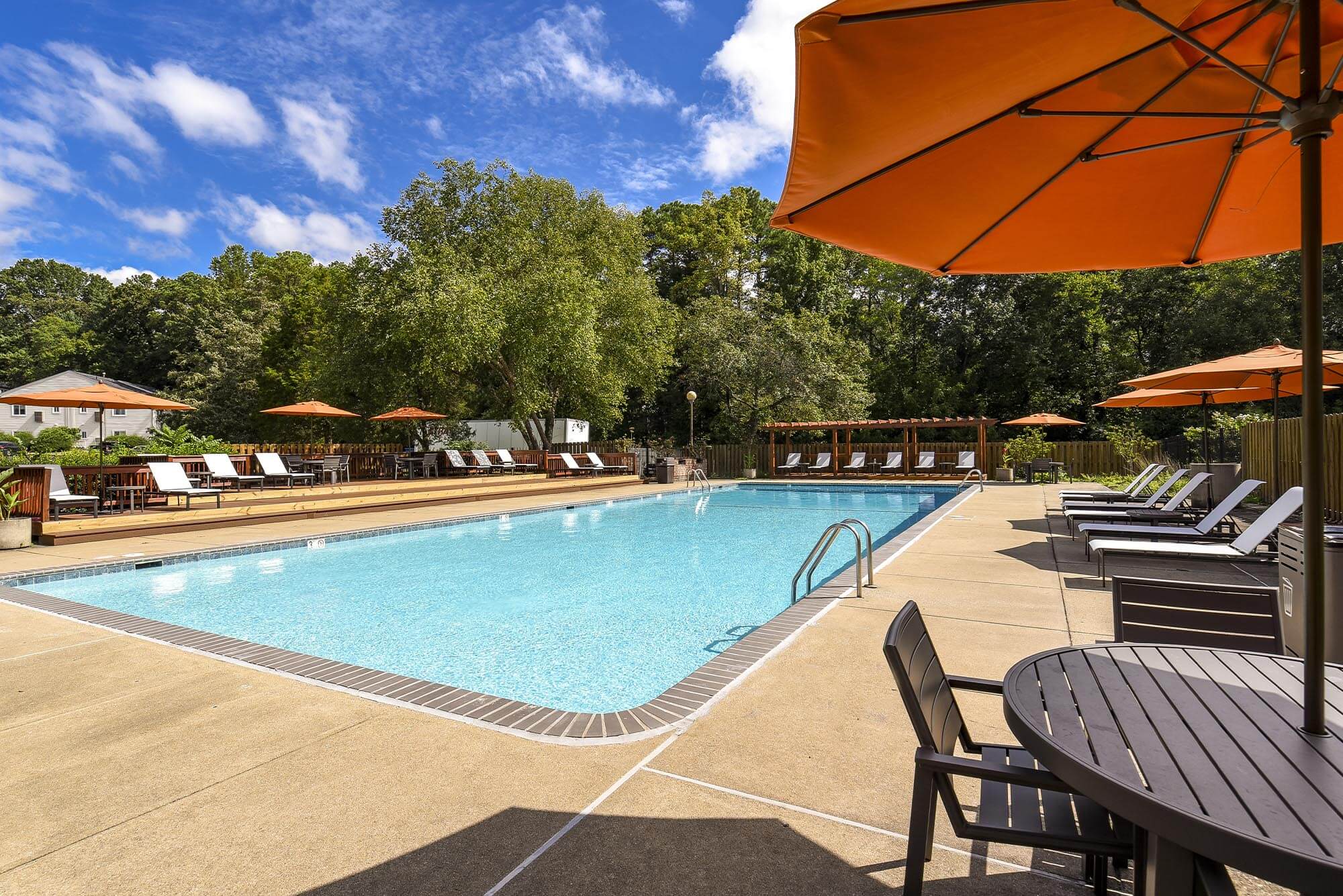Sparkling pool with lounge chairs and umbrella at Chesterfield Flats, North Chesterfield, Virginia