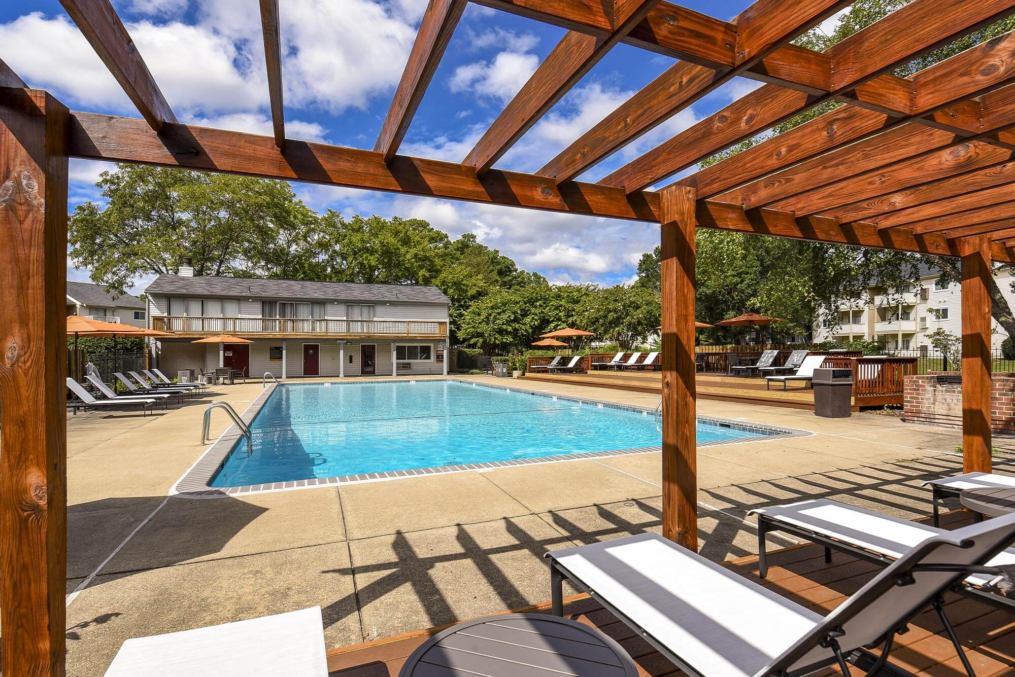 Sparkling pool with lounge chairs and umbrella at Chesterfield Flats, North Chesterfield, Virginia