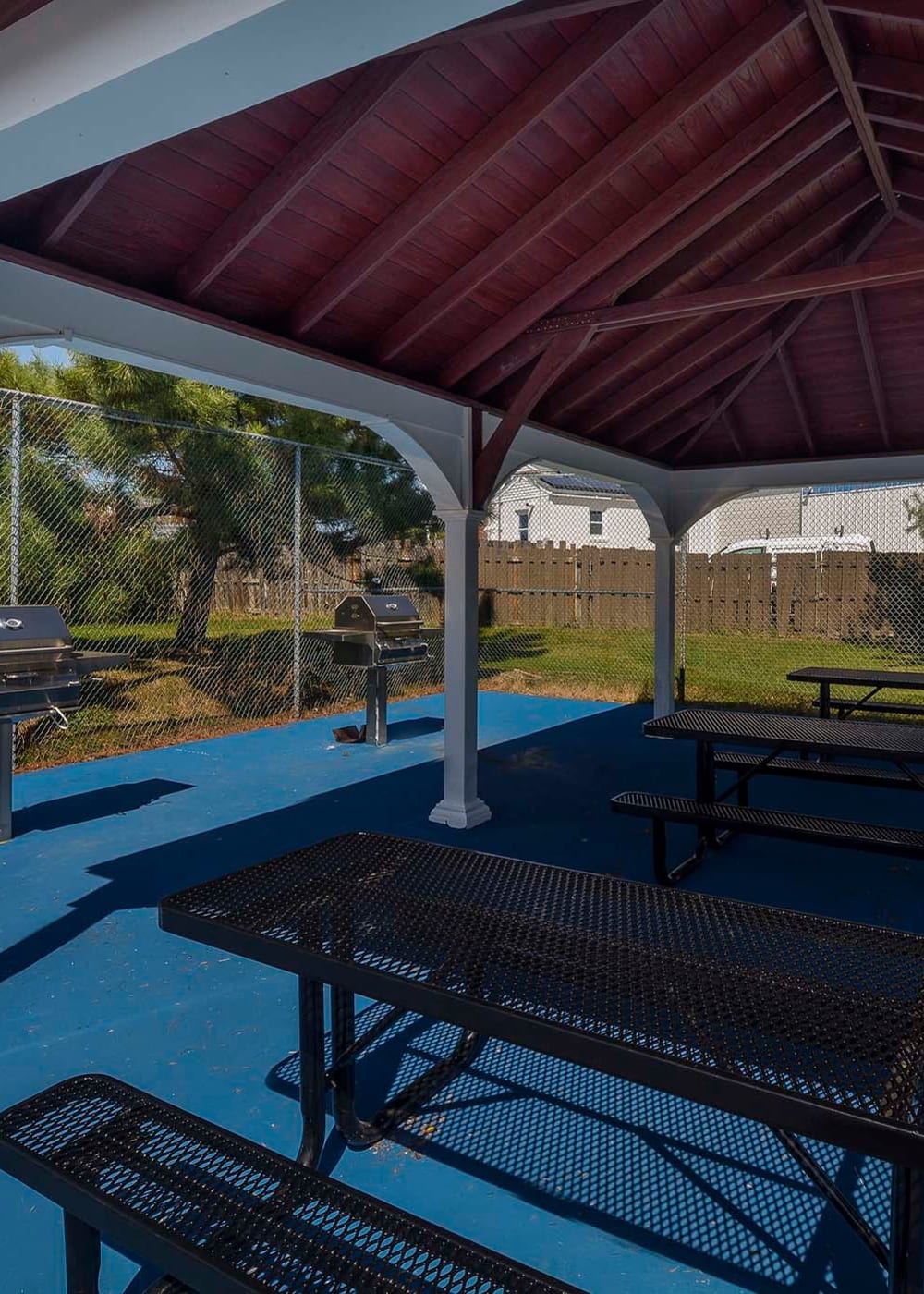 Large gazebo with multiple picnic tables underneath and nearby BBQ grills at Stonegate Apartments in Elkton, Maryland