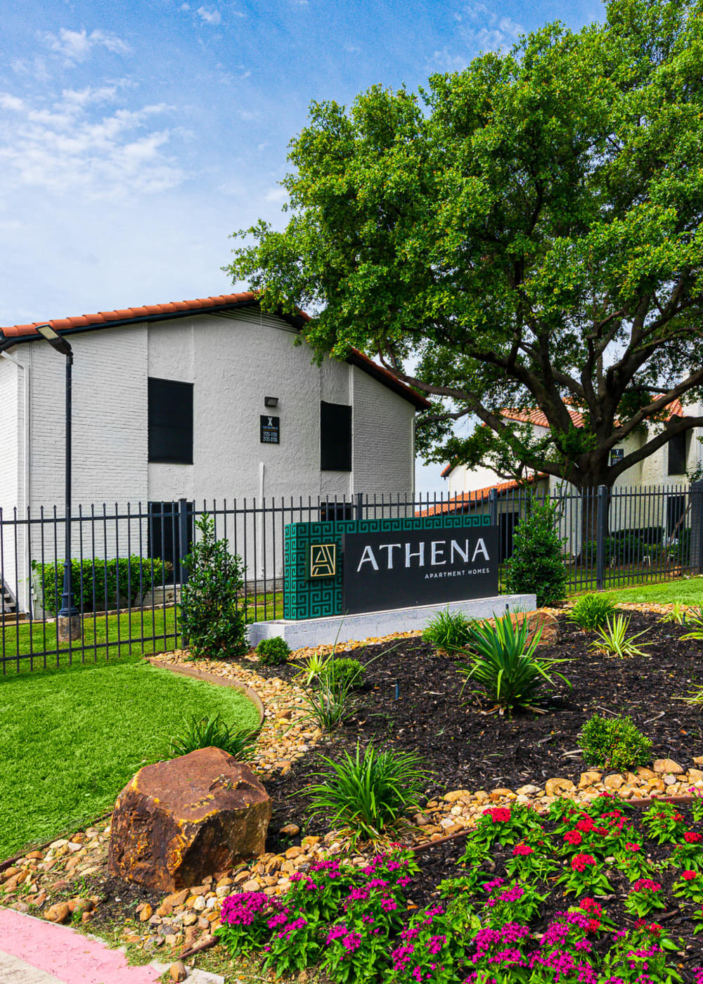 Landscaped entrance sign at Athena Apartment Homes in Benbrook, Texas
