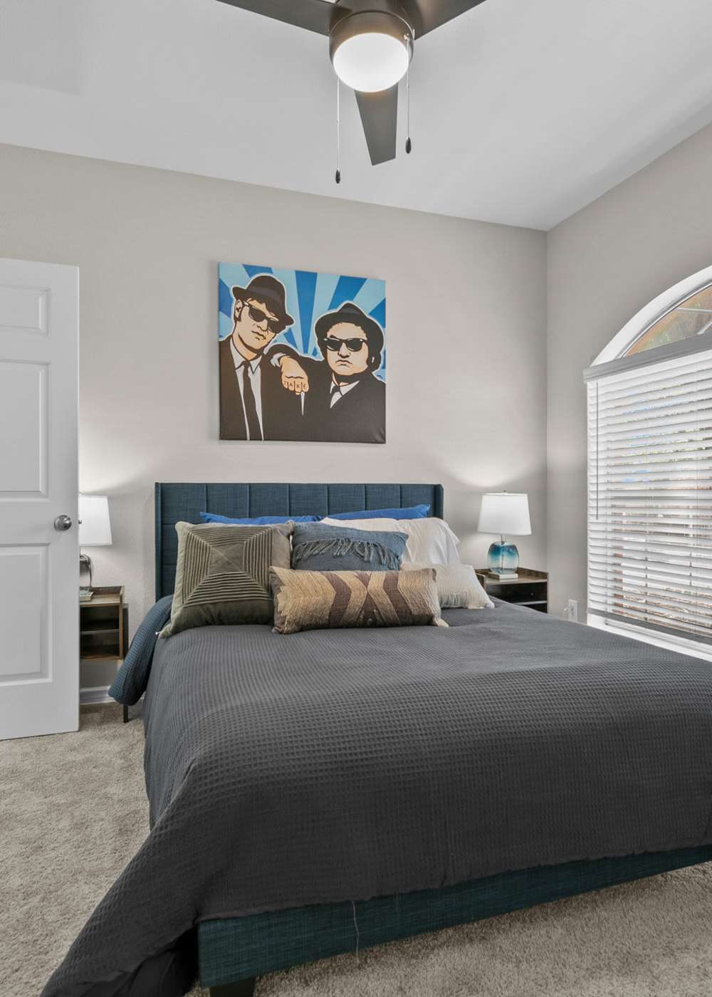 Spacious bedroom with a comfortable bed and a ceiling fan at Station 3700 in Euless, Texas