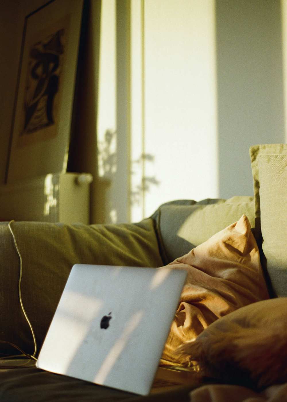 Cozy living room with laptop and soft pillows, sunlit ambiance at Colony Parc in Ventura, California