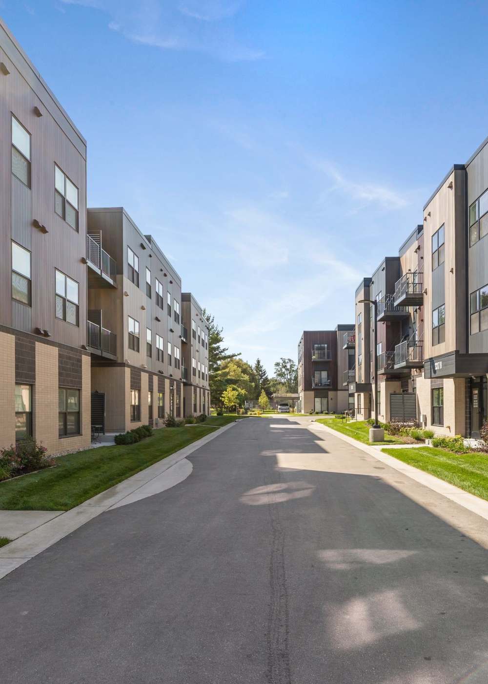 Private drive between modern apartment buildings with green landscaping at Terra Station in Hudsonville, Michigan