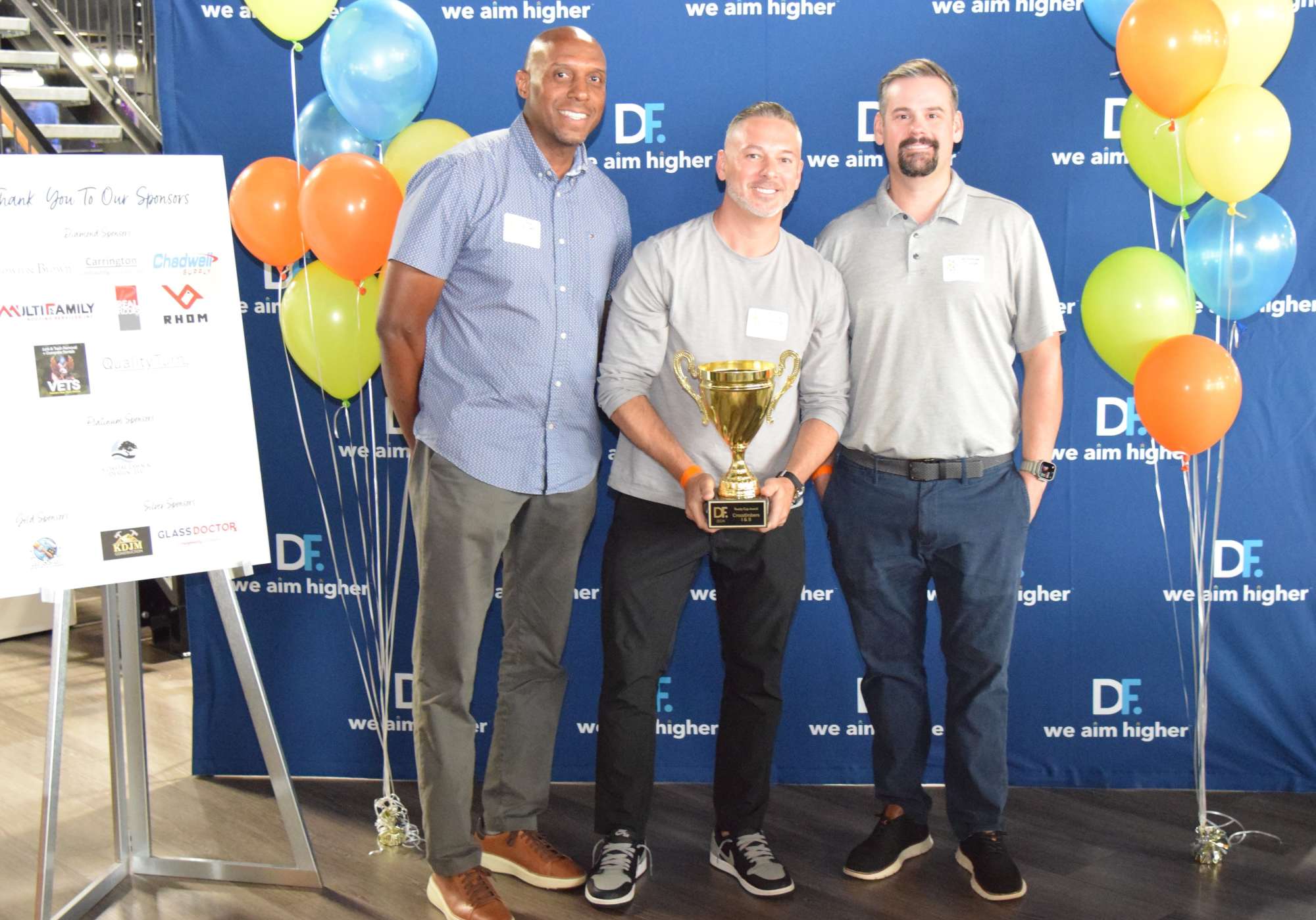 A diverse group of people receiving an award for their hardwork at Drucker + Falk in Newport News Virginia