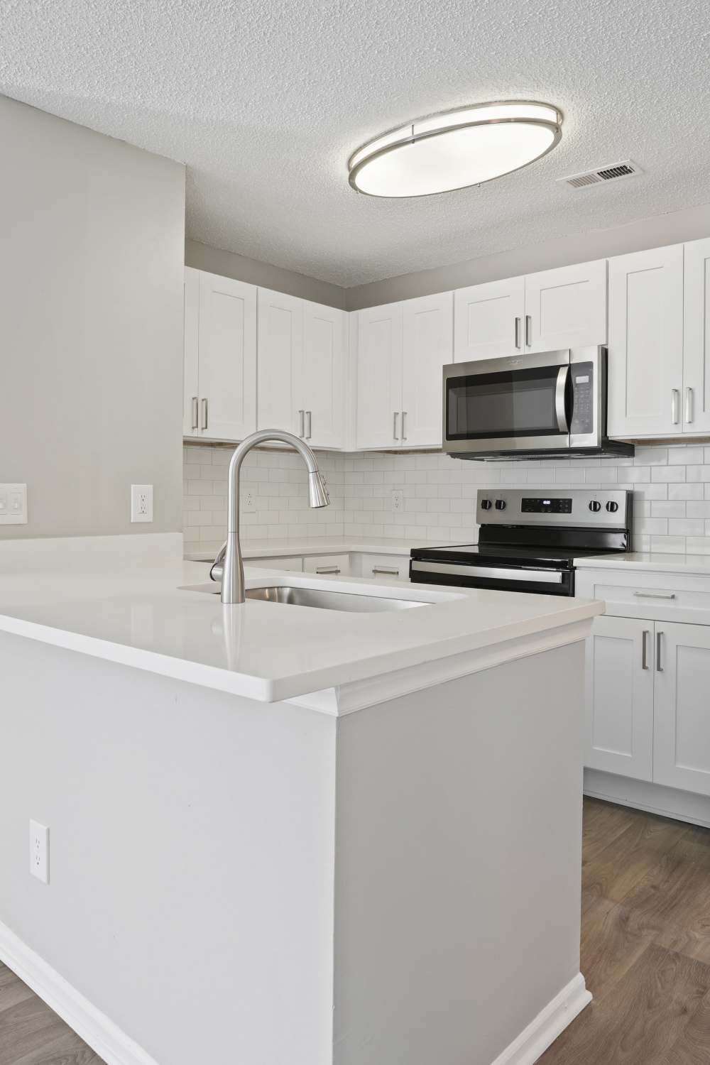 Modern kitchen with white cabinets at Niner Woods in Charlotte, North Carolina
