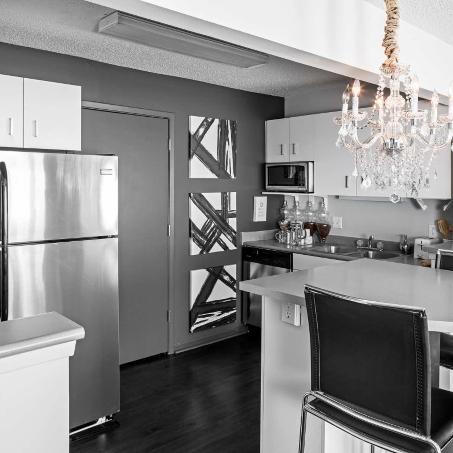 Bright modern apartment kitchen with chandelier at The Gramercy in Manhattan, Kansas