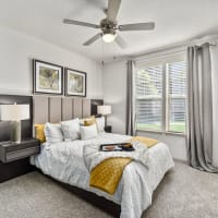 Modern furnishings in a model apartment's primary bedroom at Discovery at Kingwood in Kingwood, Texas