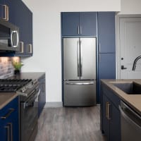 Beautiful full kitchen with stainless steel appliances and dark blue cabinets at Bellrock Sawyer Yards in Houston, Texas