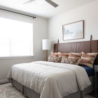 Modern furnishings in a model apartment's primary bedroom at Bellrock Memorial in Houston, Texas