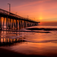 Pier at sunset with ocean waves
