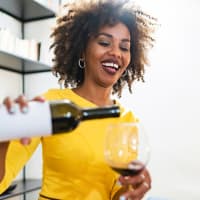 A woman pouring a glass of wine at Mode at Owings Mills in Owings Mills, Maryland