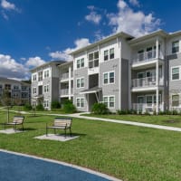 Bench seating in a grass area in front of apartments at Sentosa Riverview in Riverview, Florida