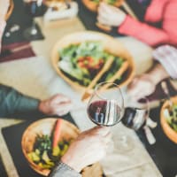 Friends drinking wine over dinner at One India Street Apartments in Boston, Massachusetts