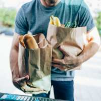 Resident holding grocery bag at Hayu Tilixam in Portland, Oregon