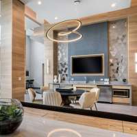 View of a common area at Azora at Cypress Ranch with a round table, chairs, and a TV screen on the wall