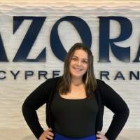 Young woman standing in front Azora at Cypress Ranch signage