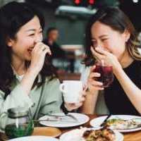 Two women sharing a laugh while having a meal near Reve Park Ridge in Little River, South Carolina